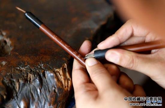 9月20日，张忠新师傅在制作好的毛笔上课上字。 新华网 姜冰摄