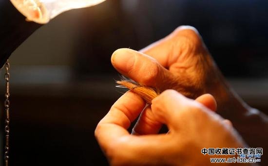 9月19日，张国茹在进行“择毛”工序，挑出笔头中的杂毛。 新华网 姜冰摄
